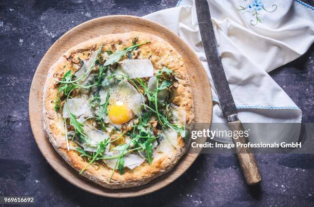 a pizza with rocket, fried egg and parmesan (seen from above) - parmesan overhead stock pictures, royalty-free photos & images