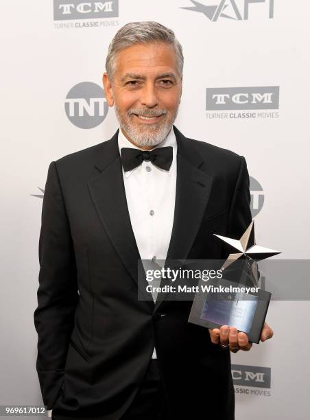 Honoree George Clooney poses with the Life Achievement trophy during the American Film Institute's 46th Life Achievement Award Gala Tribute to George...