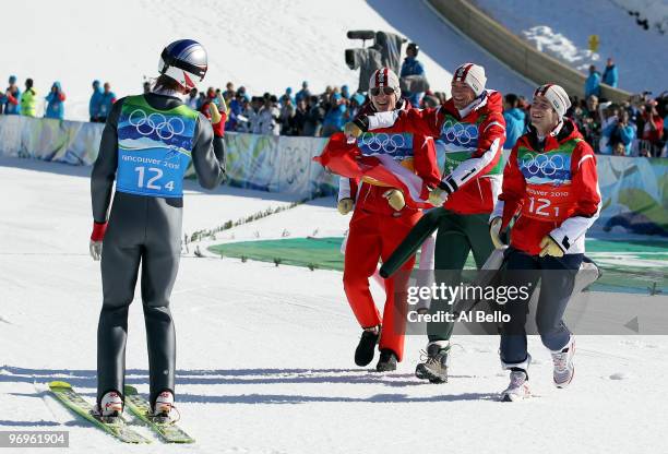 Gregor Schlierenzauer is greeted by teammates Thomas Morgenstern, Andreas Kofler, Wolfgang Loitzl of Austria after winning the gold medal in the...