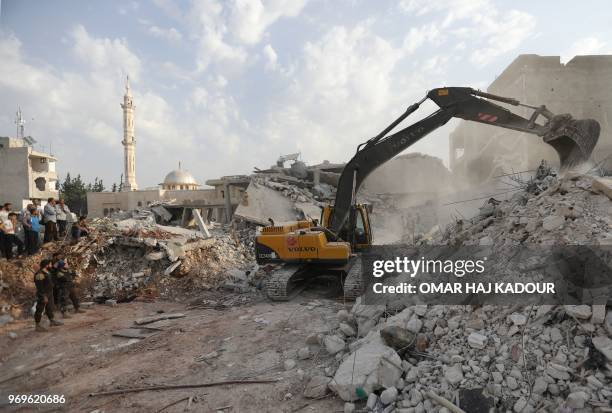 Syrians gather amidst destruction in Zardana, in the mostly rebel-held northern Syrian Idlib province, in the aftermath of air strikes in the area...