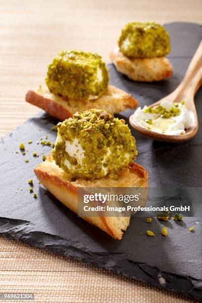 crostini with pistachio-coated goat's cheese - amuse bouche stockfoto's en -beelden