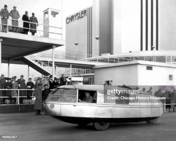 View of the Gulf Dymaxion car as it drives past the Chrysler Motors Building at the Century of Progress International Exposition , Chicago, Illinois,...