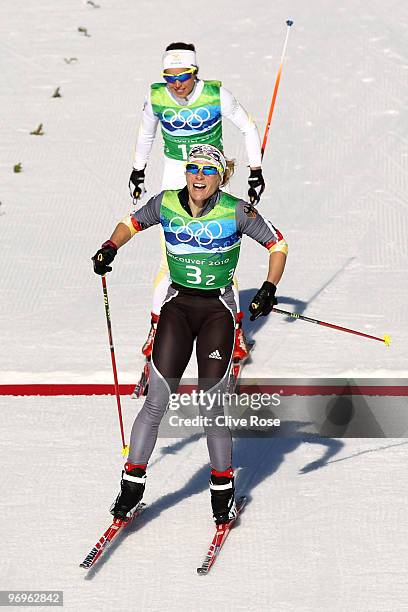 Claudia Nystad of Germany crosses the finish line ahead of Anna Haag of Sweden during the cross country skiing ladies team sprint final on day 11 of...