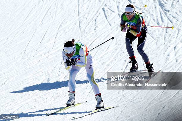 Charlotte Kalla of Sweden and Evi Sachenbacher-Stehle of Germany compete during the cross country skiing ladies team sprint final on day 11 of the...