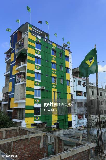 This photograph taken on June 5, 2018 shows the facade of a residential building decorated with the colours and national flag of Brazil after a...