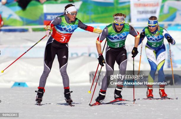 Evi Sachenbacher-Stehle and Claudia Nystad of Germany and Riikka Sarasoja of Finland compete during the cross country skiing ladies team sprint final...