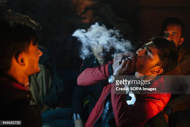 Locals smoking marijuana with sadhus during Shivaratri festival celebrations at Pashupatinath temple in Kathmandu, Nepal. Shivaratri or The Night of...