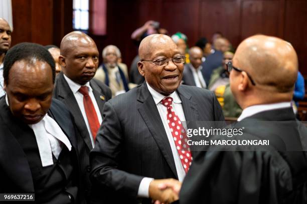 Former South African President Jacob Zuma greets his team at the end of the hearing at the Durban Magistrate Court in Durban, on June 8, 2018. - He...