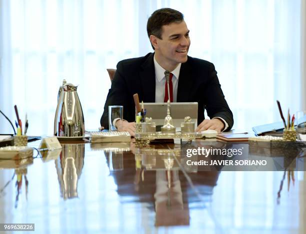 Spanish Prime Minister Pedro Sanchez smiles as he chairs his first cabinet meeting at La Moncloa palace in Madrid on June 8, 2018. - King Felipe VI...