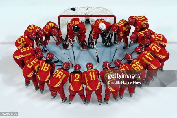 Team China huddles in a circle as they get set to play against Slovakia during the ice hockey women's classification 7th/8th game on day 11 of the...