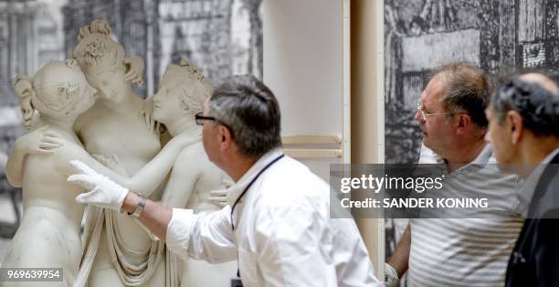 Museum workers prepare the sculpture 'The Three Graces' by Italian Antonio Canova for the exhibition 'Classic Beauties' at the Hermitage Museum in...