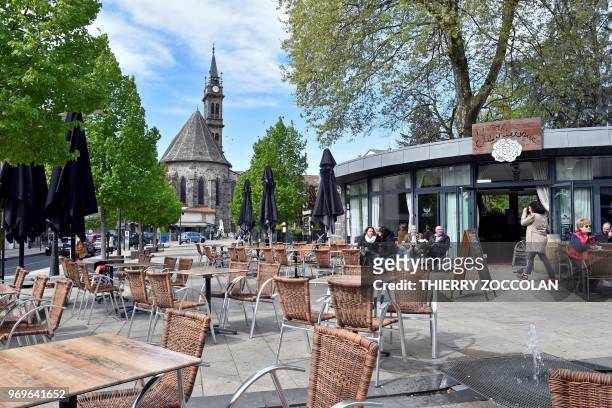 Picture taken on May 2, 2018 shows the Place du Square Vermenouze and the churhc Notre Dame Aux Neiges in Aurillac. - The initiative "A roof, a job"...