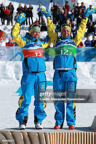 Charlotte Kalla and Anna Haag of Sweden celebrate silver during the flower ceremony for the women's team sprint cross-country skiing on day 11 of the...