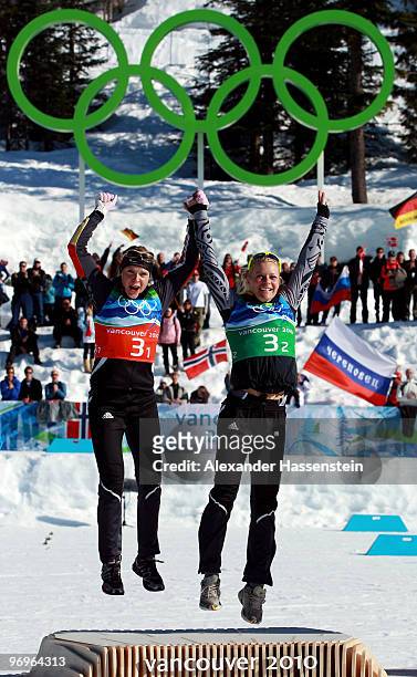 Evi Sachenbacher-Stehle and Claudia Nystad of Germany celebrate winning the gold medal during the flower ceremony for the women's team sprint...