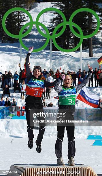 Evi Sachenbacher-Stehle and Claudia Nystad of Germany celebrate winning the gold medal during the flower ceremony for the women's team sprint...