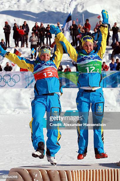 Charlotte Kalla and Anna Haag of Sweden celebrate silver during the flower ceremony for the women's team sprint cross-country skiing on day 11 of the...