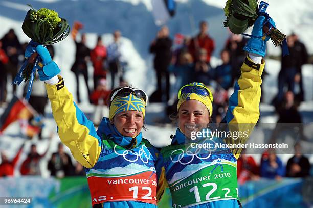 Charlotte Kalla and Anna Haag of Sweden celebrate silver during the flower ceremony for the women's team sprint cross-country skiing on day 11 of the...