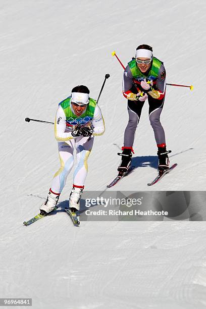 Charlotte Kalla of Sweden and Evi Sachenbacher-Stehle of Germany compete during the cross country skiing ladies team sprint final on day 11 of the...