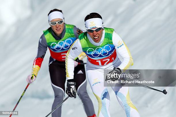 Evi Sachenbacher-Stehle of Germany and Charlotte Kalla of Sweden compete during the cross country skiing ladies team sprint final on day 11 of the...