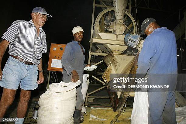 Former Zimbabwean farmer John Browning supervises workers at his at a factory in the Zimbabwean capital Harare on February 9,2010 after losing his...