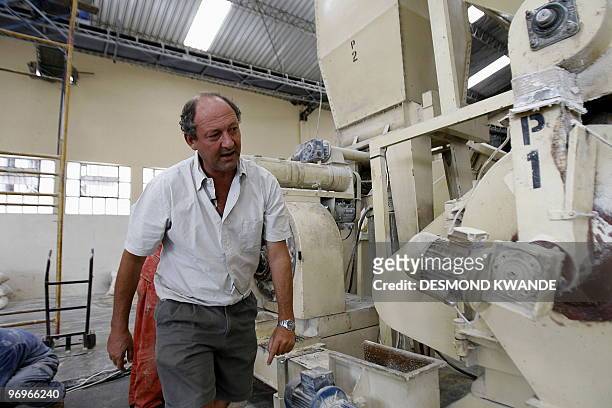 Former Zimbabwean farmer Tim Philp is seen at his new workplace at in a factory in the Zimbabwean capital Harare on February 3, 2010 after losing his...