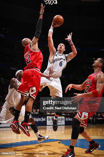 Mike Miller of the Washington Wizards shoots against Taj Gibson and Brad Miller of the Chicago Bulls at the Verizon Center on February 22, 2010 in...