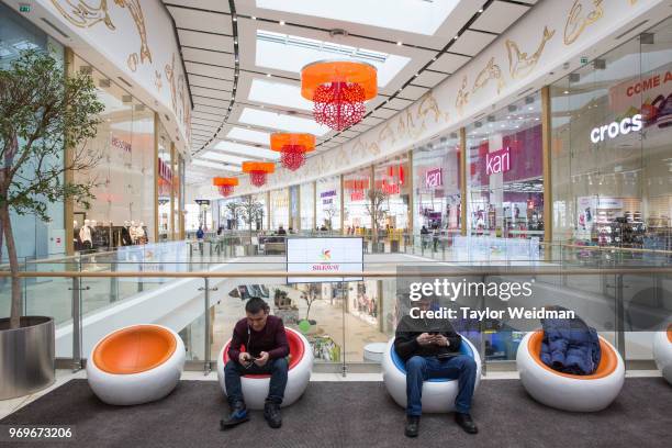 Men use their phones in the Mega Silkways mall in Astana, Kazakhstan. Kazakhstan is changing its alphabet from Cyrillic script to the Latin script...