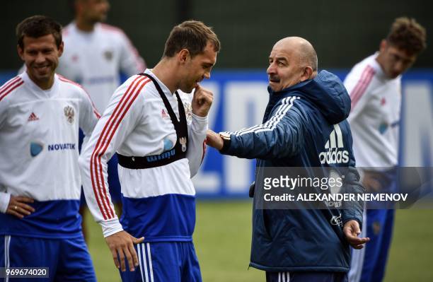 Russia's coach Stanislav Cherchesov talks to Russia's forward Artyom Dzyuba during a training session of the Russian national football team in...