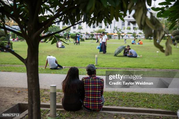 Burmese men and women spend time in a park near Sule Pagoda in Yangon, Myanmar.