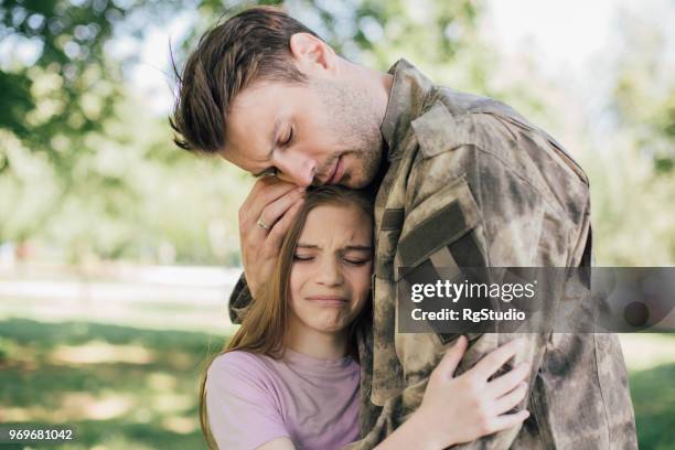 triste soldado que abrazaba con su hija - echar de menos fotografías e imágenes de stock