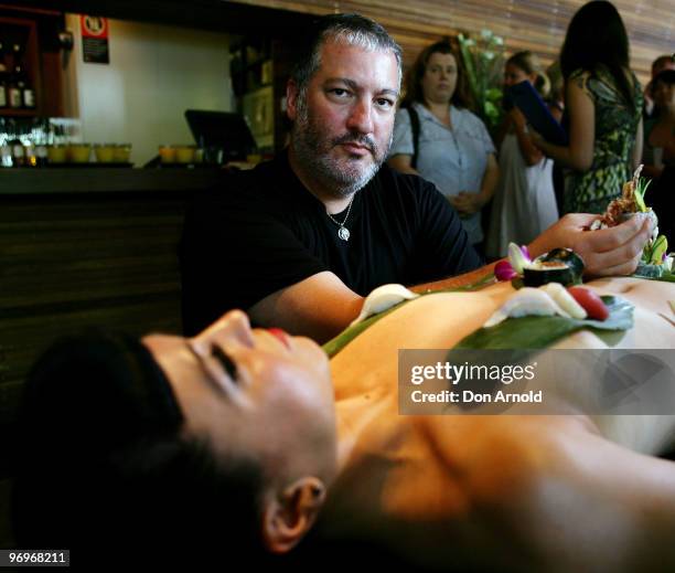 New York artist Spencer Tunick poses whilst standing over a model dressed only with sushi aT a press conference at the Toko Restaurant & Bar on...