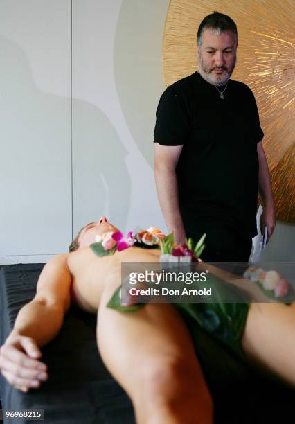 New York artist Spencer Tunick poses whilst standing over a model dressed only with sushi during a press conference at the Toko Restaurant & Bar on...