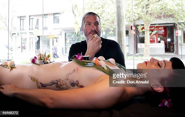 New York artist Spencer Tunick poses whilst standing over a model dressed only with sushi aT a press conference at the Toko Restaurant & Bar on...