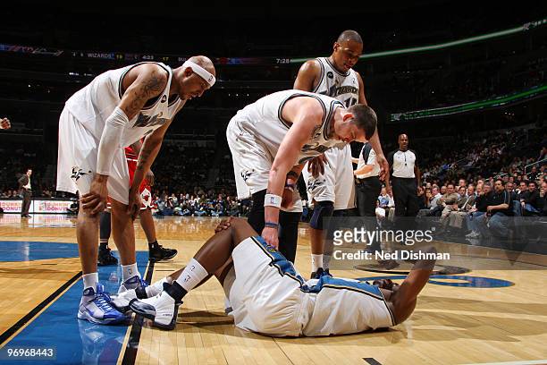 Josh Howard of the Washington Wizards lies on the floor injured surrounded by Mike Miller, James Singleton and Randy Foye during game against the...