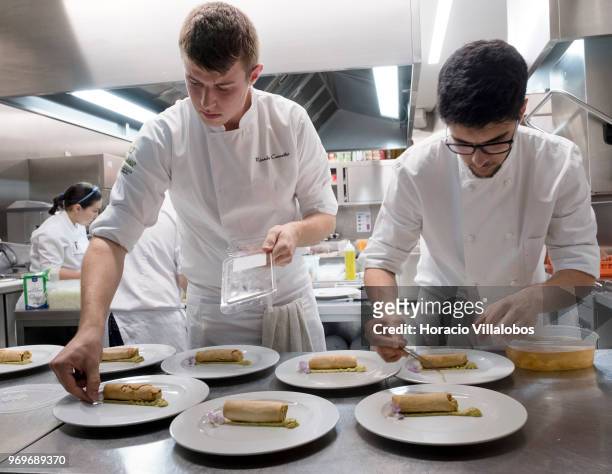 Members of the kitchen staff decorate dishes of Smoked Salmon Canilha, smoked salmon in a roll of brick pastry with ginger, guacamole and pickles, at...