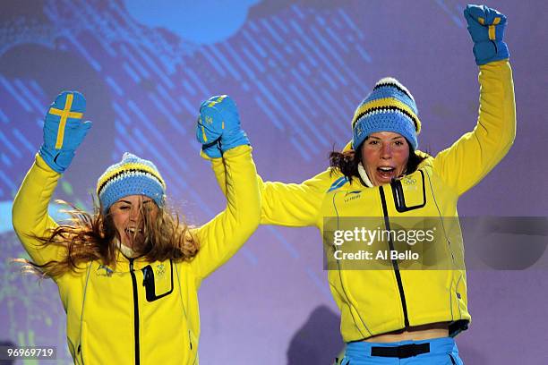 Anna Haag and Charlotte Kalla of Sweden receive the silver medal during the medal ceremony for the women's team sprint cross-country skiing on day 11...