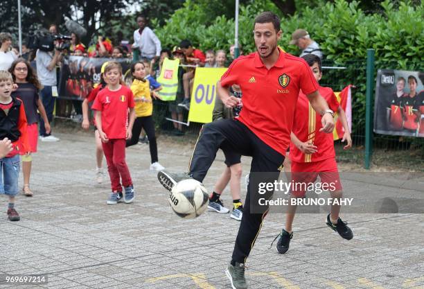 Belgium's forward Eden Hazard plays football with pupils of the Ecole Fondamentale de Clabecq in Clabecq, Belgium on June 8, 2018. - The Red Devils...