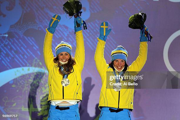 Anna Haag and Charlotte Kalla of Sweden receive the silver medal during the medal ceremony for the women's team sprint cross-country skiing on day 11...