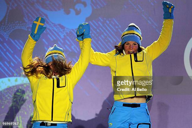 Anna Haag and Charlotte Kalla of Sweden receive the silver medal during the medal ceremony for the women's team sprint cross-country skiing on day 11...