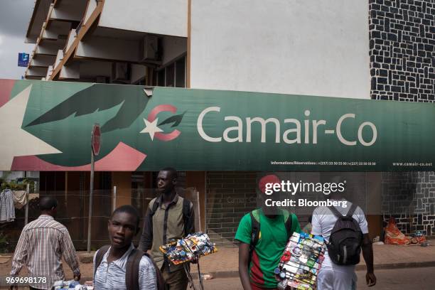 Street vendors sell goods in front of a Cameroon Airlines SA office building in Yaounde, Cameroon, on Monday, June 4, 2018. Cameroon adjusted its...