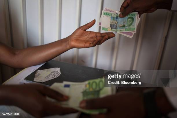 Customer exchanges Central African franc banknotes for Euro banknotes in a money exchange booth in the Bastos neighborhood, Yaounde, Cameroon, on...