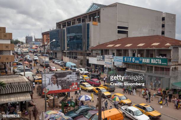 Taxis and automobiles make their way along the street by Yaounde's central market in Yaounde, Cameroon, on Monday, June 4, 2018. Cameroon adjusted...