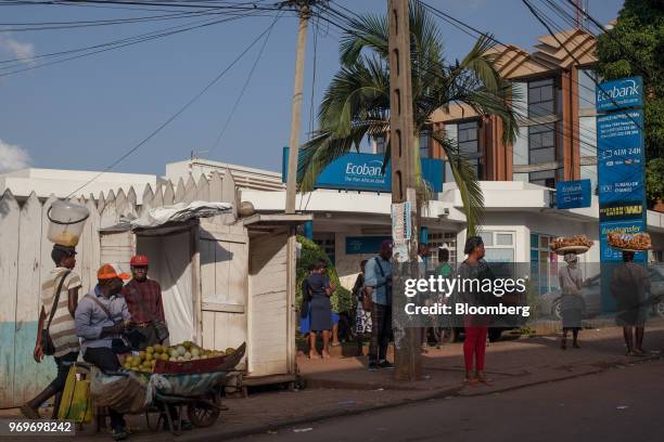 Pedestrians walk by a branch of Ecobank Cameroon in Yaounde, Cameroon, on Tuesday, June 5, 2018. Cameroon adjusted its 2018 budget to 4.69 trillion...
