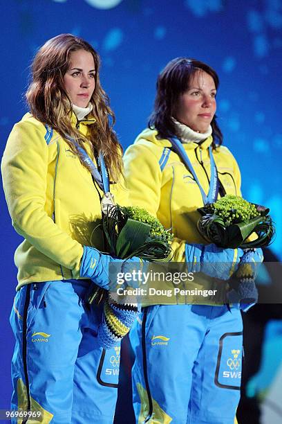 Anna Haag and Charlotte Kalla of Sweden receive the silver medal during the medal ceremony for the women's team sprint cross-country skiing on day 11...