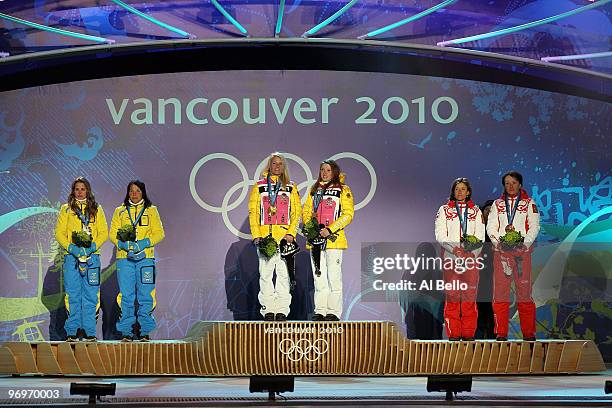 Anna Haag and Charlotte Kalla of Sweden receive the silver medal, Claudia Nystad and Evi Sachenbacher-Stehle of Germany receive the gold medal and...