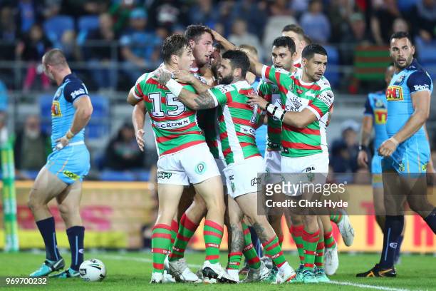 Sam Burgess of the Rabbitohs celebrates a try with team mates during the round 14 NRL match between the Gold Coast Titans and the South Sydney...