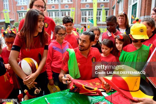 Belgium's midfielder Nacer Chadli signs autographs during a visit of the Belgium's national football team to a Brussels school called Ecole Primaire...