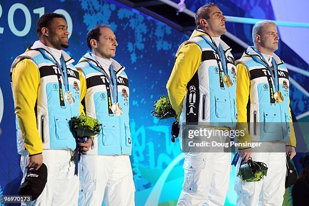 Richard Adjei and Thomas Florschuetz of Germany receive the silver medal, and Kevin Kuskeand Andre Lange of Germany receive the gold medal during the...