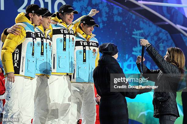 The German team receives the silver medal during the medal ceremony for the men's team ski jumping held at the Whistler Medals Plaza on day 11 of the...