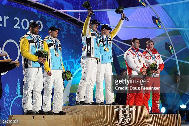 Richard Adjei and Thomas Florschuetz of Germany receive the silver medal, Kevin Kuske and Andre Lange of Germany receive the gold medal and Alexey...